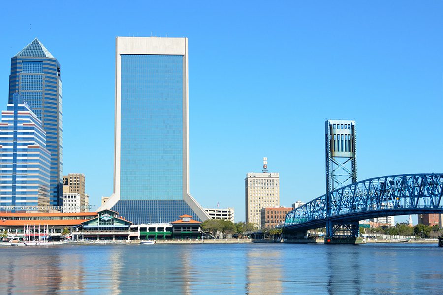 Jacksonville, FL - Far View of Jacksonville Florida Cityscape Displaying Tall Buildings, a Bridge, and the Ocean